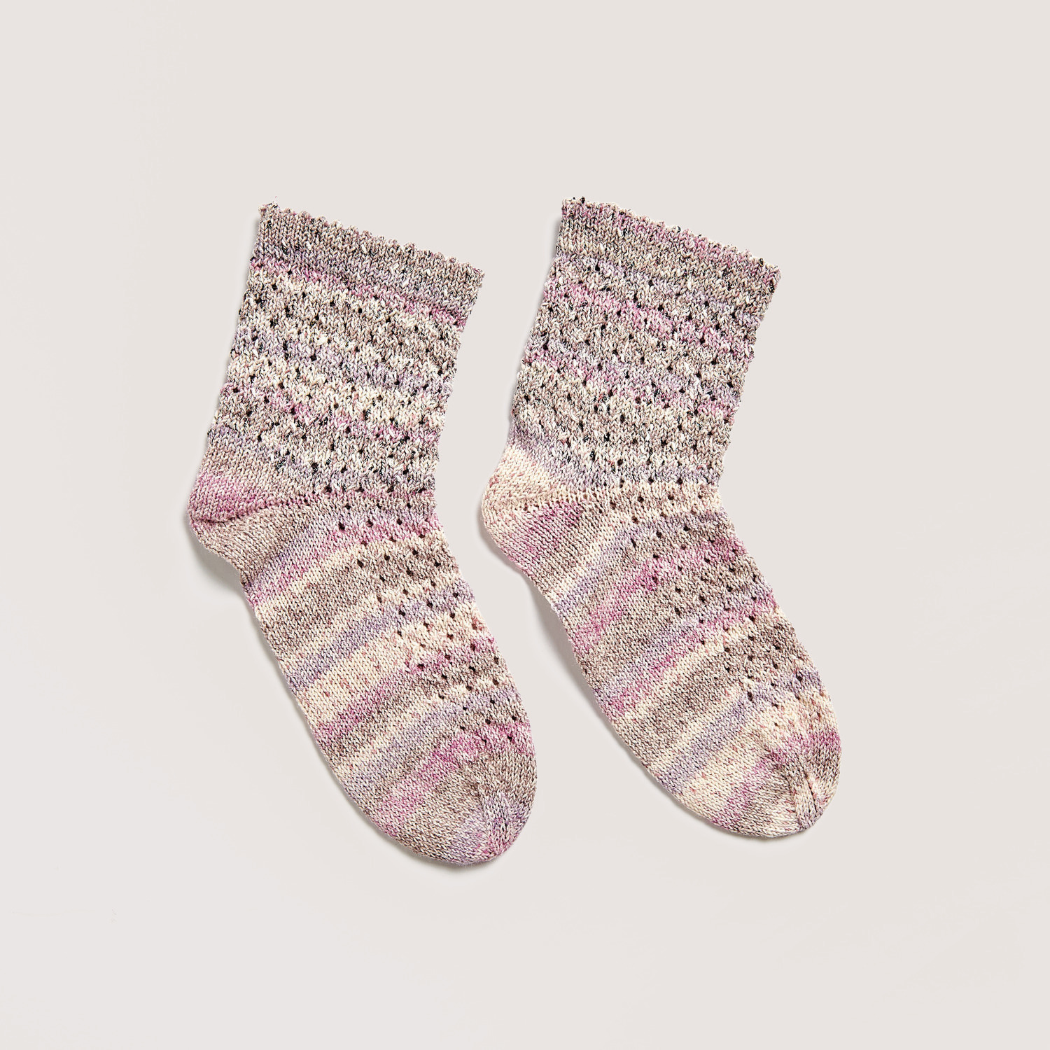 Strickset Socken Modell 14b aus Die Neue Masche No. 12, gestrickt in zarten Mauve- und Naturtönen. Ideal für kreative Strickprojekte.