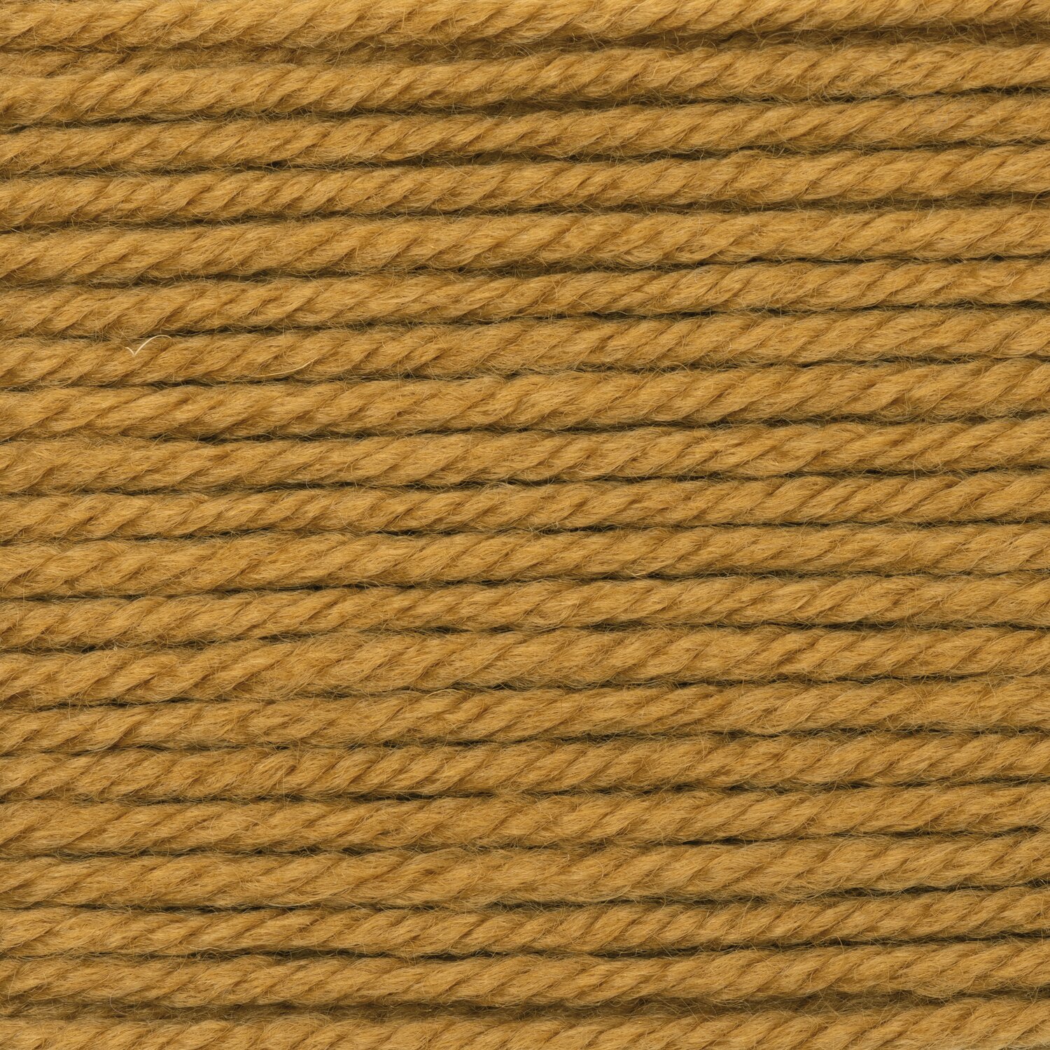 Essentials Mega Wool chunky von Rico Design, dichter Nahaufnahme-Ausschnitt des Garns in warmem Goldton, Struktur der Fasern, Lauflänge 100g 115m sichtbar