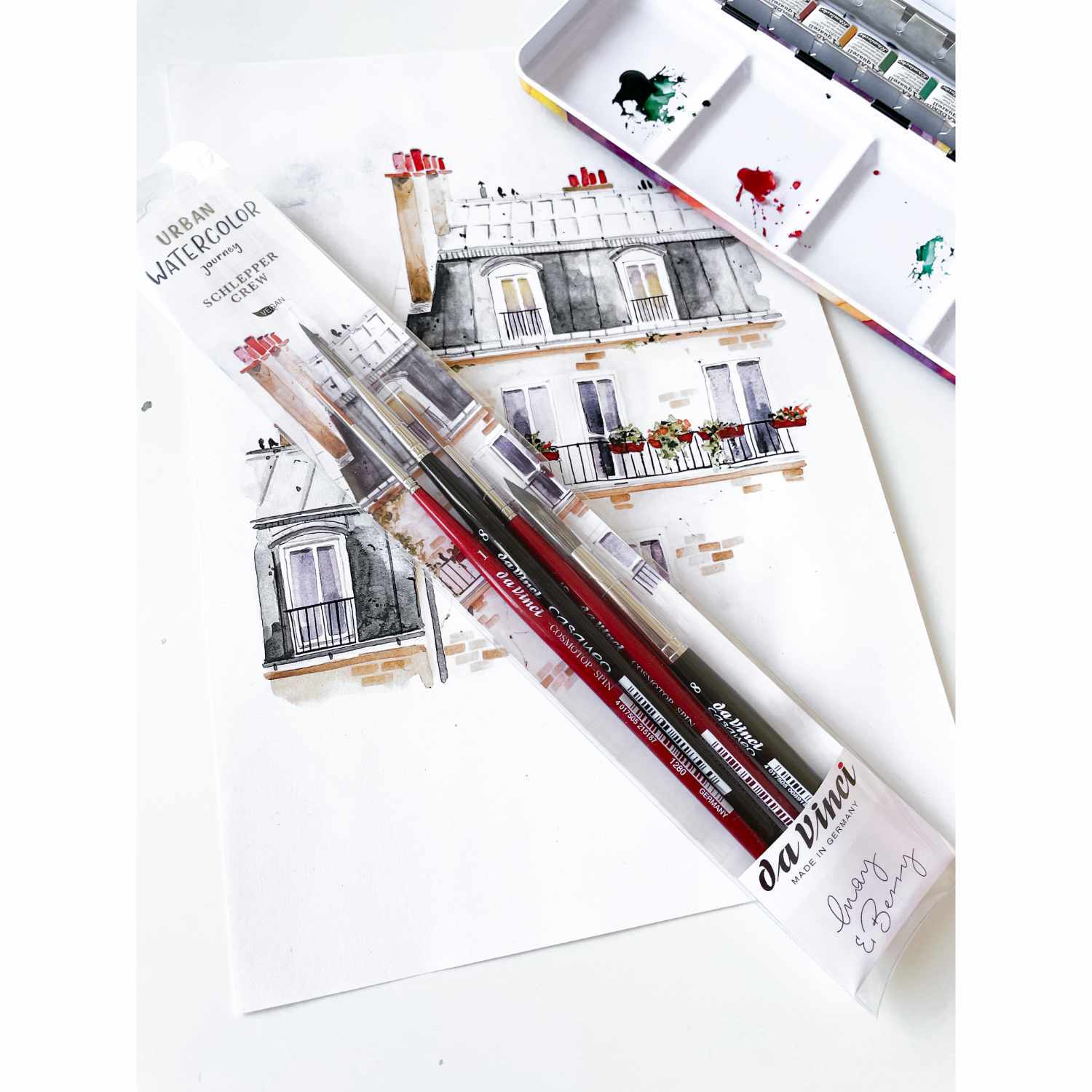da Vinci Pinsel-Set Urban Watercolor Schlepper Crew vor einem Aquarellbild einer Pariser Hausfassade mit Farbmischpalette im Hintergrund.