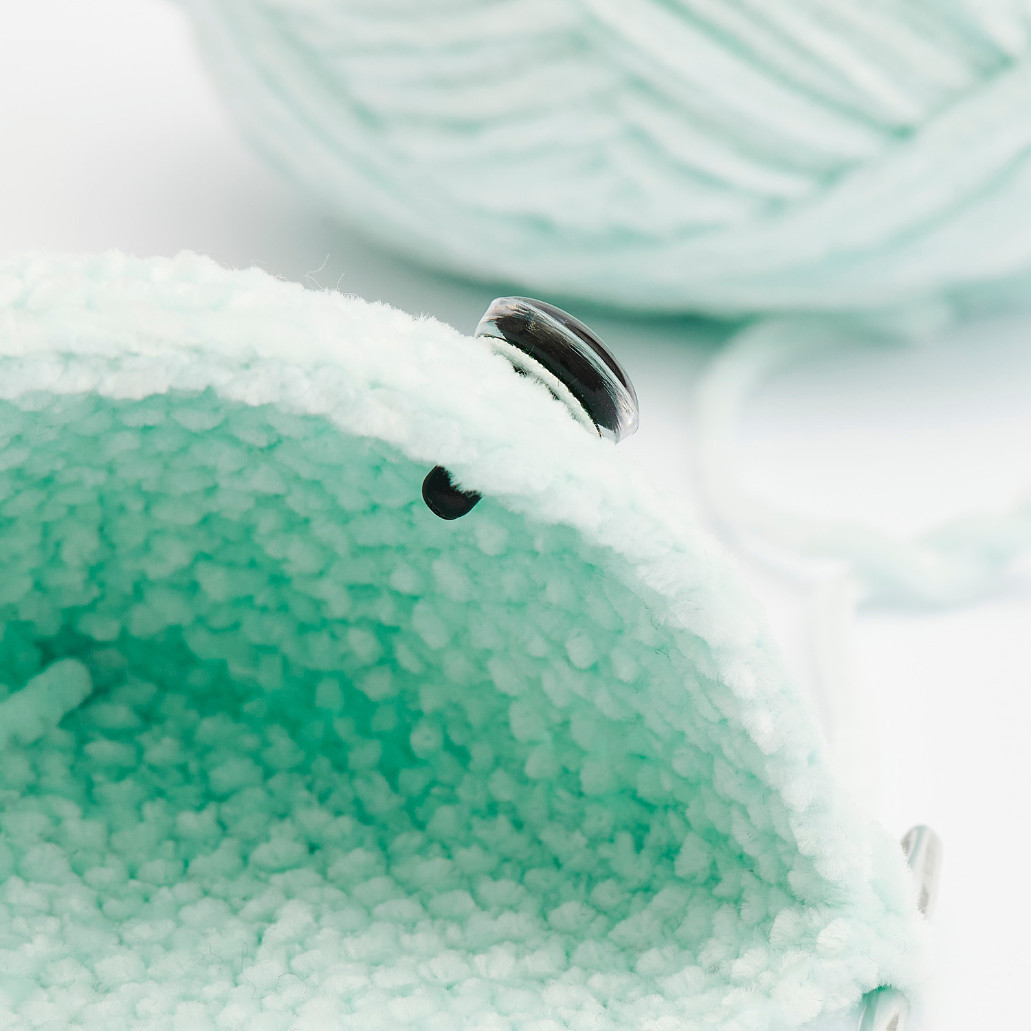 Sicherheitsaugen-Set für Kuscheltiere 6 Farben von Rico Design, Nahaufnahme eines gestrickten Stoffes mit Sicherheitsaugen.