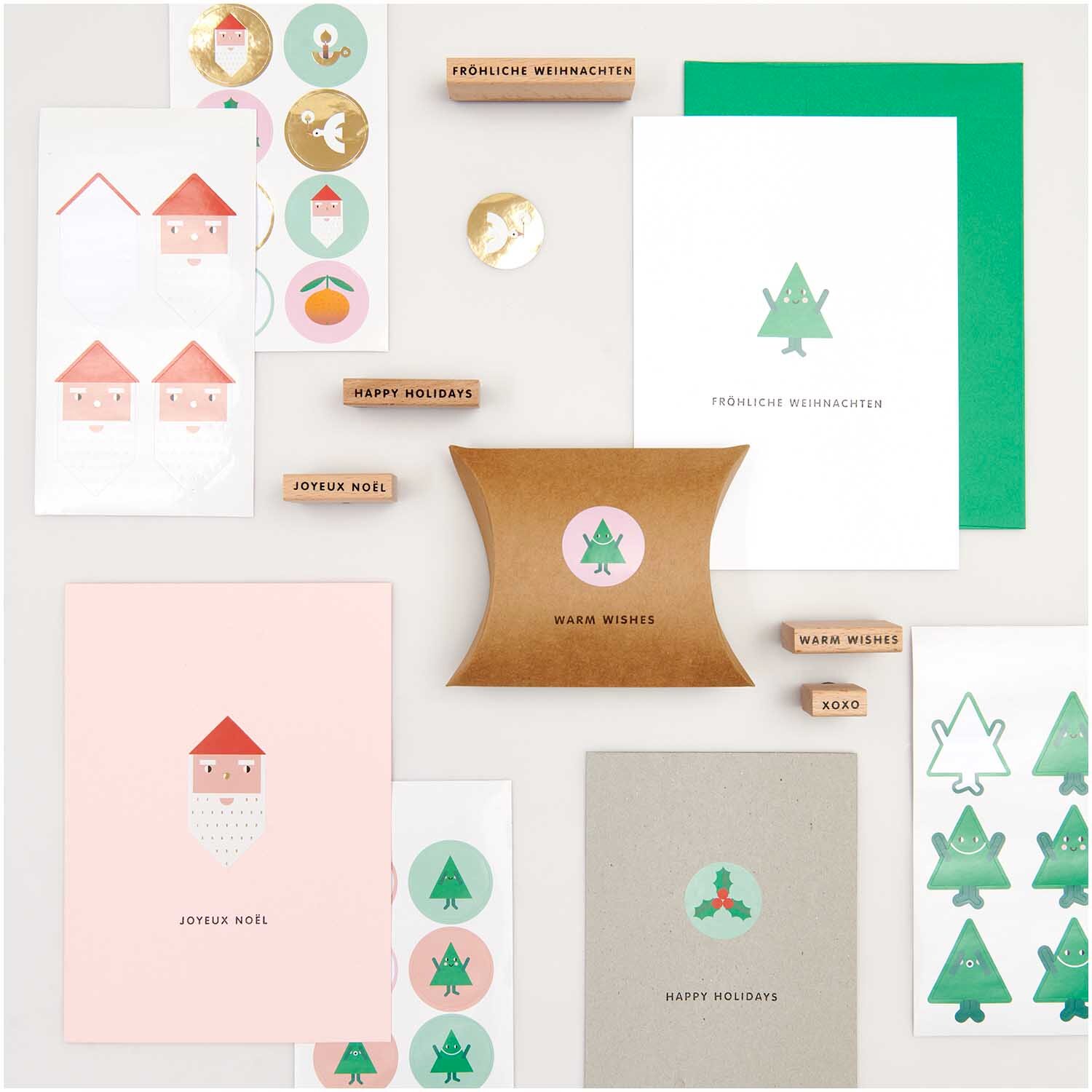 Paper Poetry Sticker Tannenbäume 4 Blatt: Verschiedene Weihnachtskarten und Sticker mit Tannenbaum-Motiven von Rico Design auf einem Tisch arrangiert.
