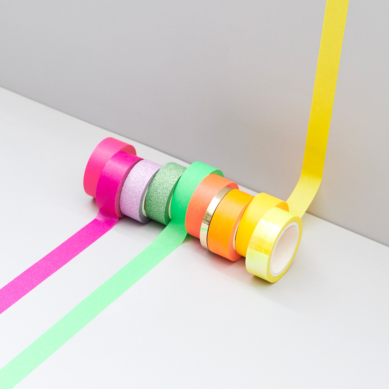 Washi Tapes einfarbig farblich sortiert und teilweise aufgeklebt. Fotosetting graue Ecke.
