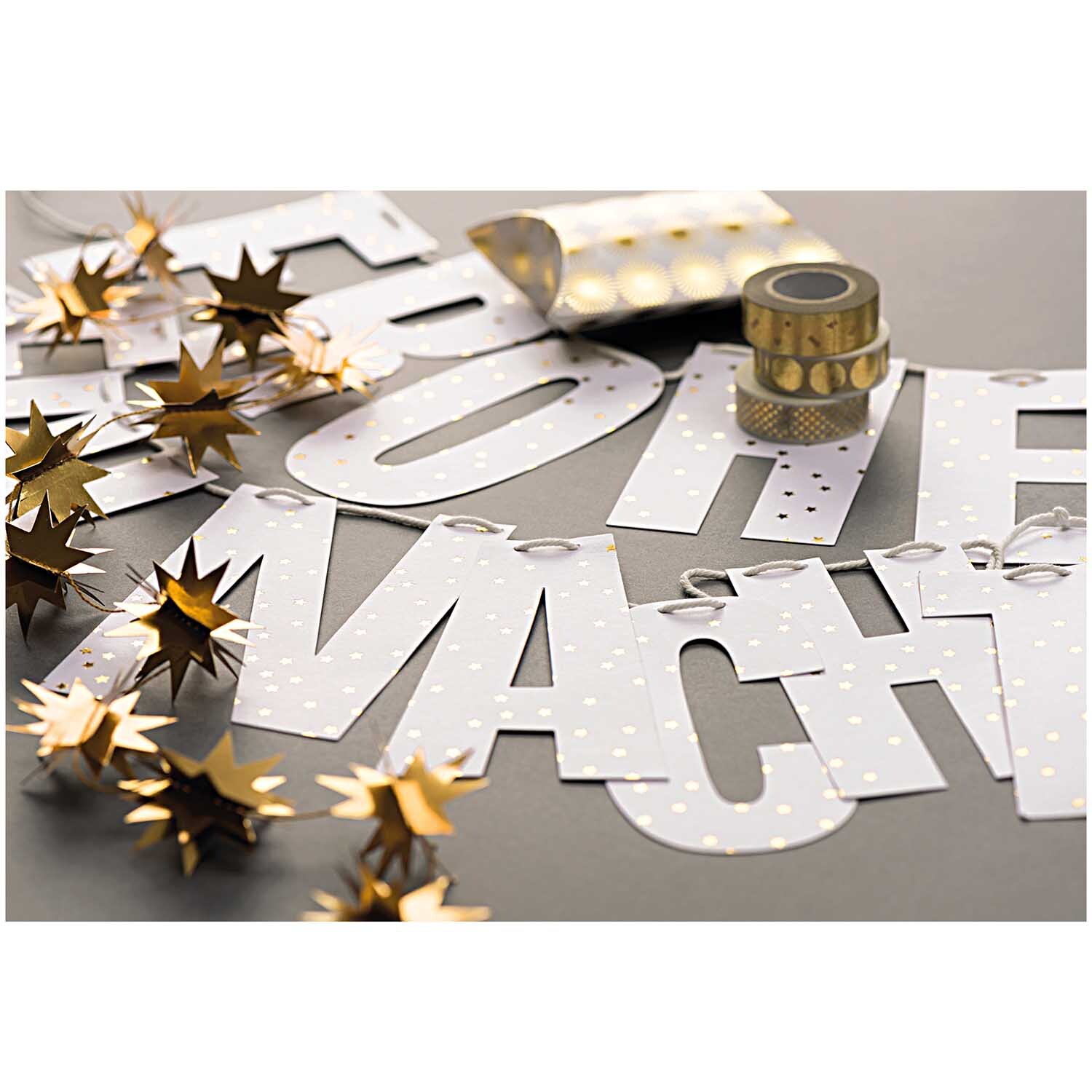 Paper Poetry Girlande Frohe Weihnachten 3m Hot Foil zeigt eine festliche Girlande mit goldenen Sternen und dekorativem Washi-Tape auf grauem Hintergrund.