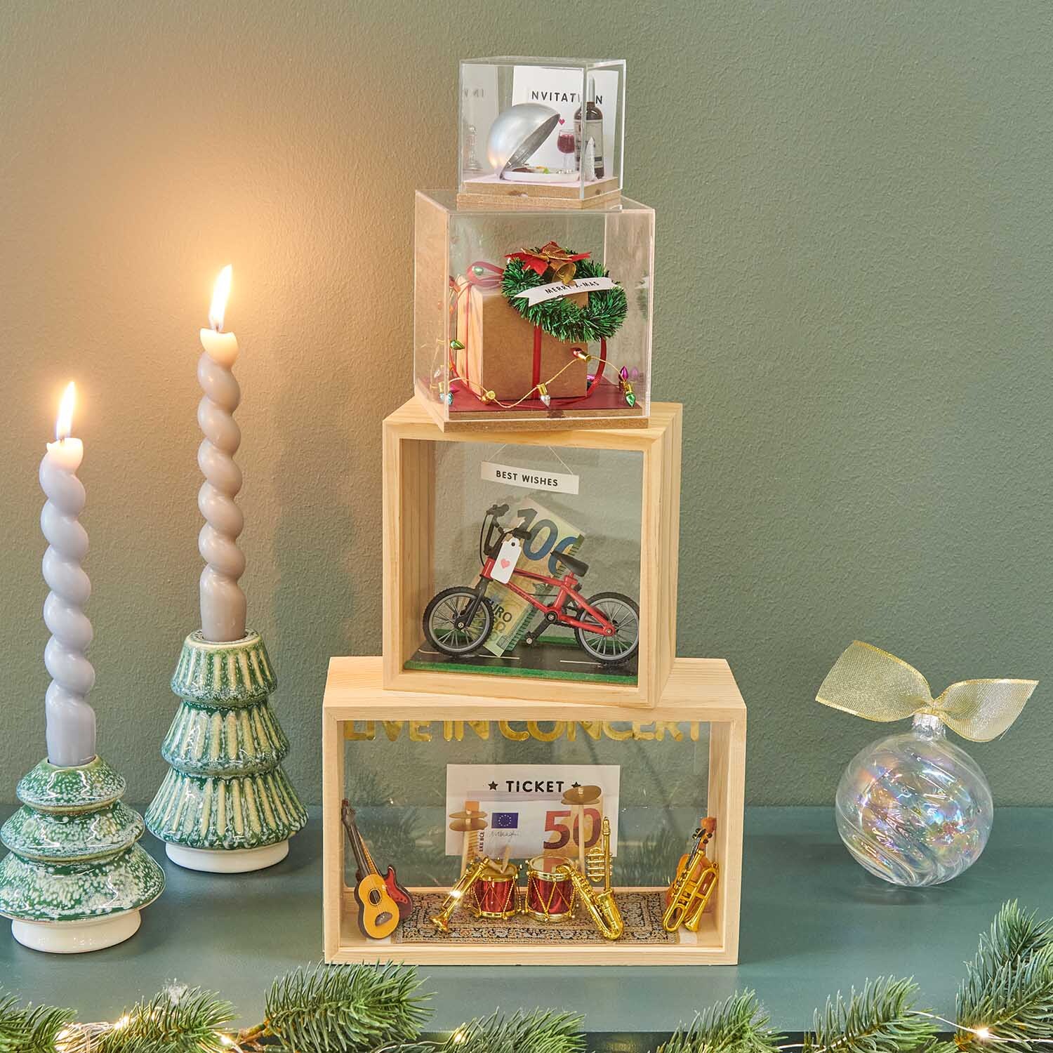 Bastelanleitung Geldgeschenk für Weihnachten: Drei dekorative Boxen mit Geschenken und Kerzen.