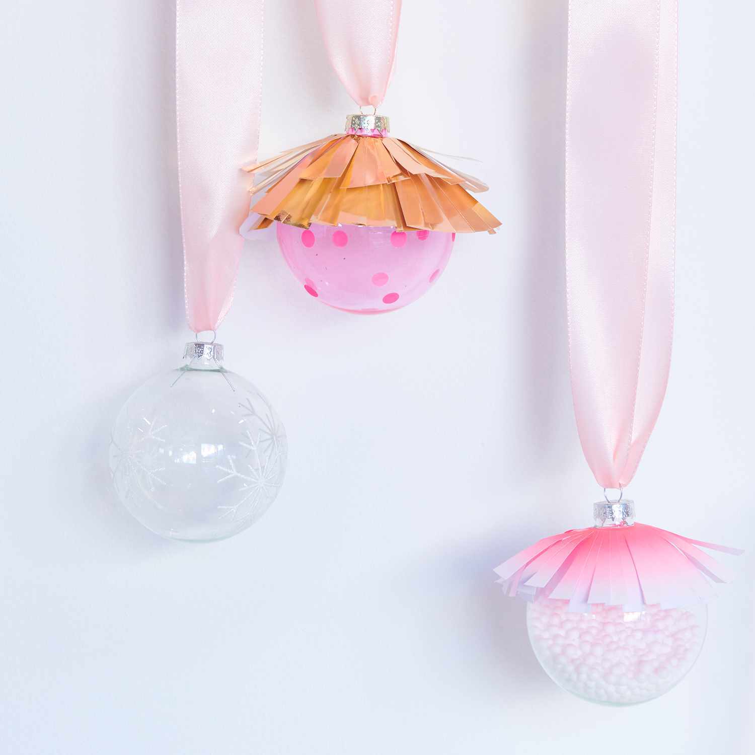 Bastelanleitung Christbaumkugeln mit Neon Details: Drei dekorative Kugeln mit rosa Bändern und kreativen Neonakzenten.