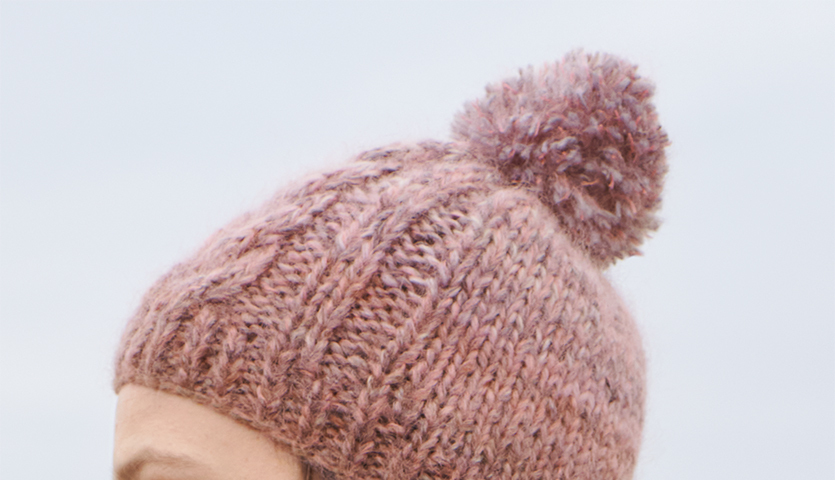 Strickanleitung Mütze aus Creative Mohair Melange: Rosa gestrickte Mütze mit Bommel, ideal für kalte Tage.