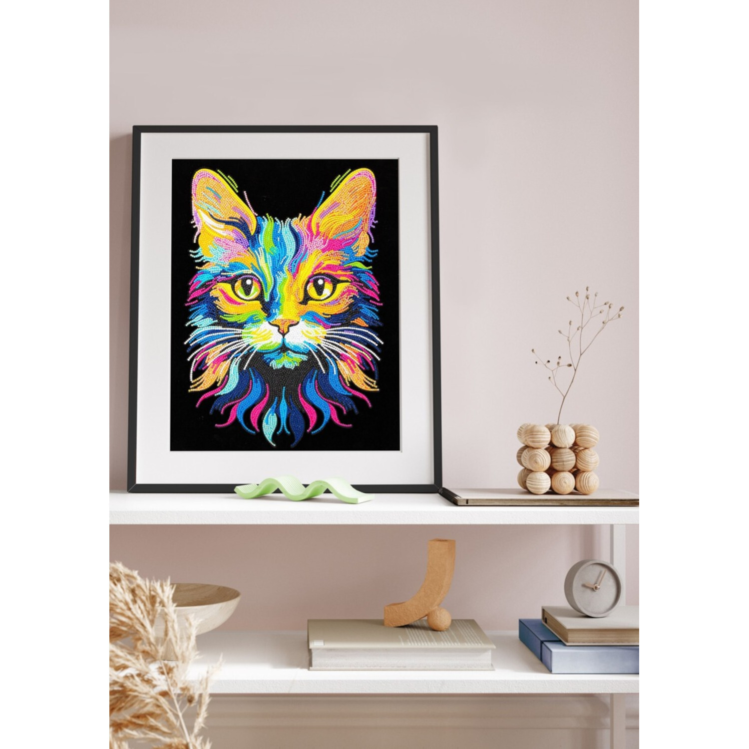 Diamond Painting Neon Katze: Buntes Katzenbild in Schwarz gerahmt, auf einem Regal platziert.