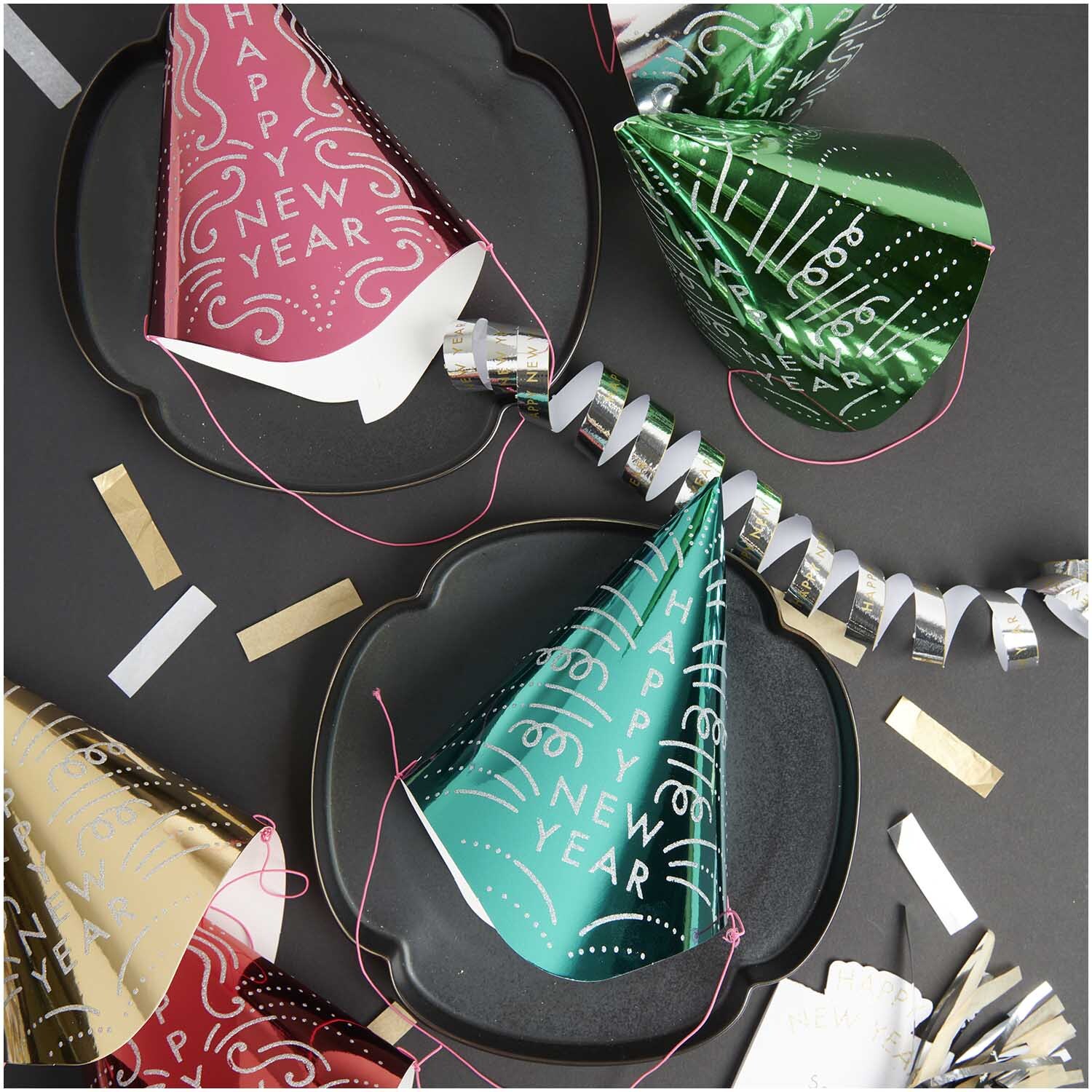 Paper Poetry Partyhüte in verschiedenen Farben auf einem Tisch, ideal für Silvesterfeiern.