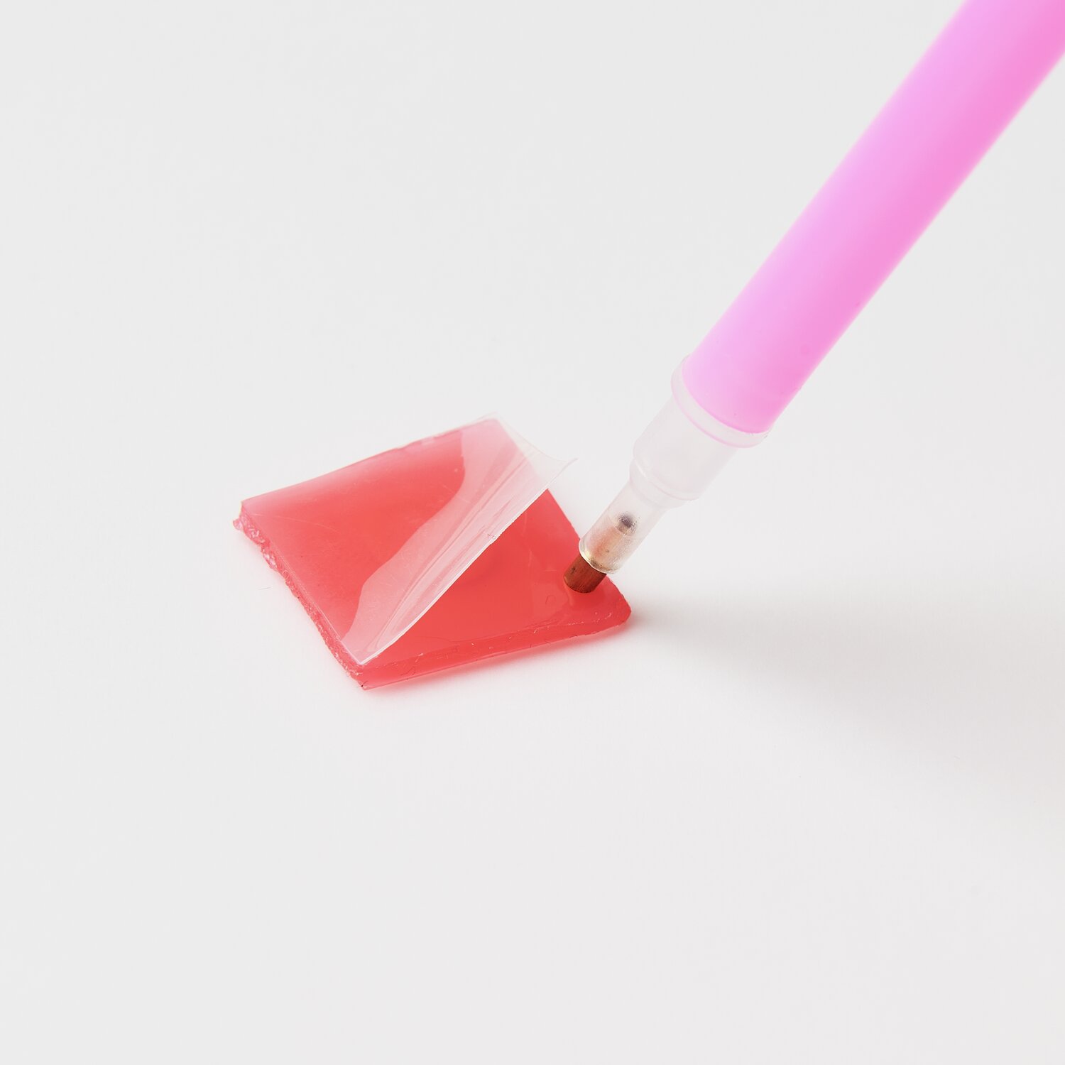 Diamond Painting DIY-Set Schimmernde Blumen 19-teilig: Rosa Stift auf rotem Wachsblock.