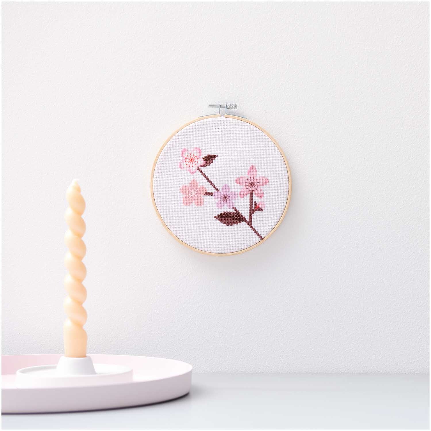 Stickpackung Kirschzweig Bild Ø 15cm zeigt zarte rosa Blüten auf weißem Hintergrund, präsentiert von Rico Design.