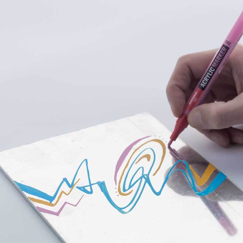 Acrylic Marker 1-2mm zeichnet bunte Linien auf Papier. Hand hält einen rosa Marker von AMSTERDAM. Ideal für kreative Designs.