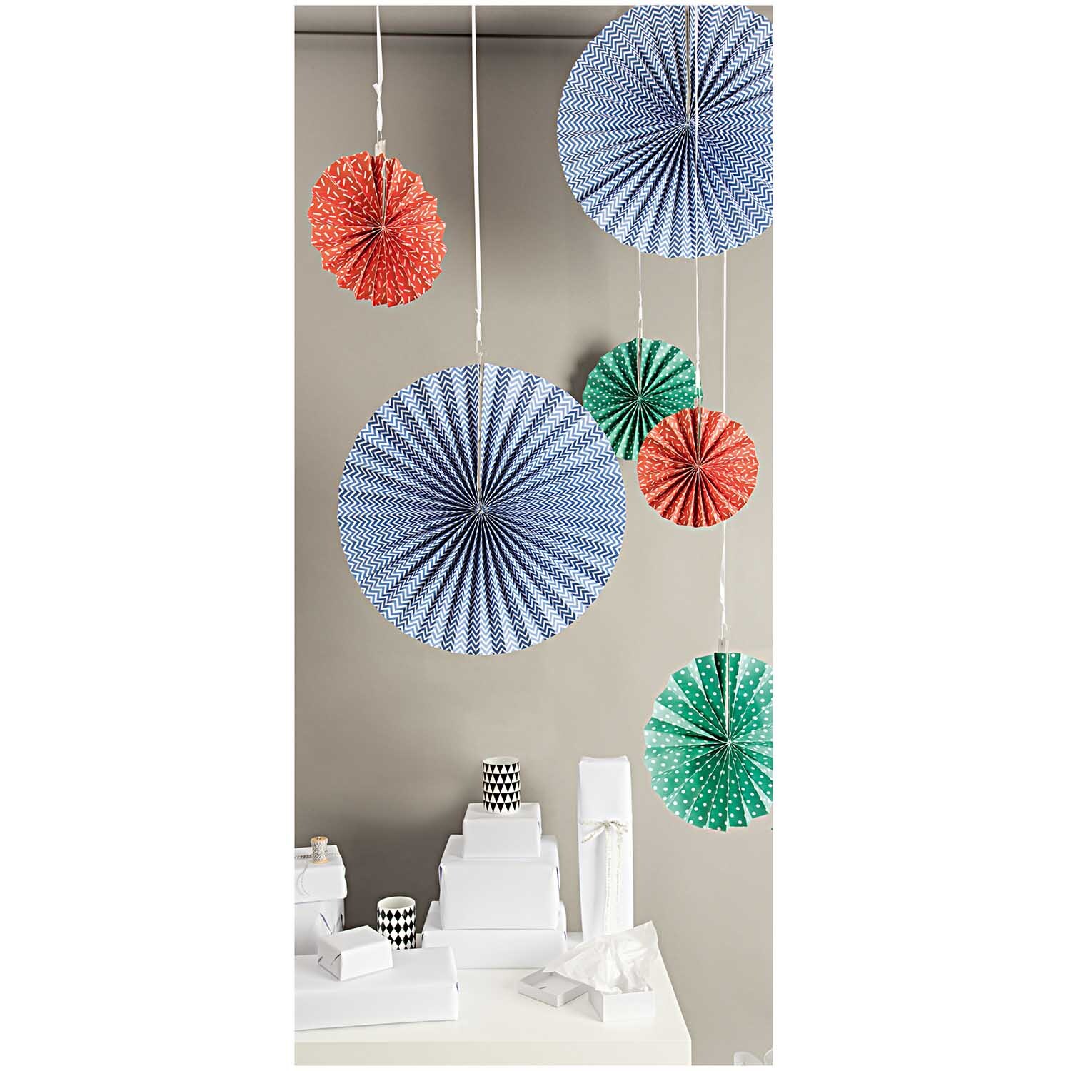 Fächer mehrfarbig Papier 3 Stück von Rico Design: Dekorative Papierfächer in Blau, Rot und Grün hängen von der Decke und verleihen dem Raum Farbe.