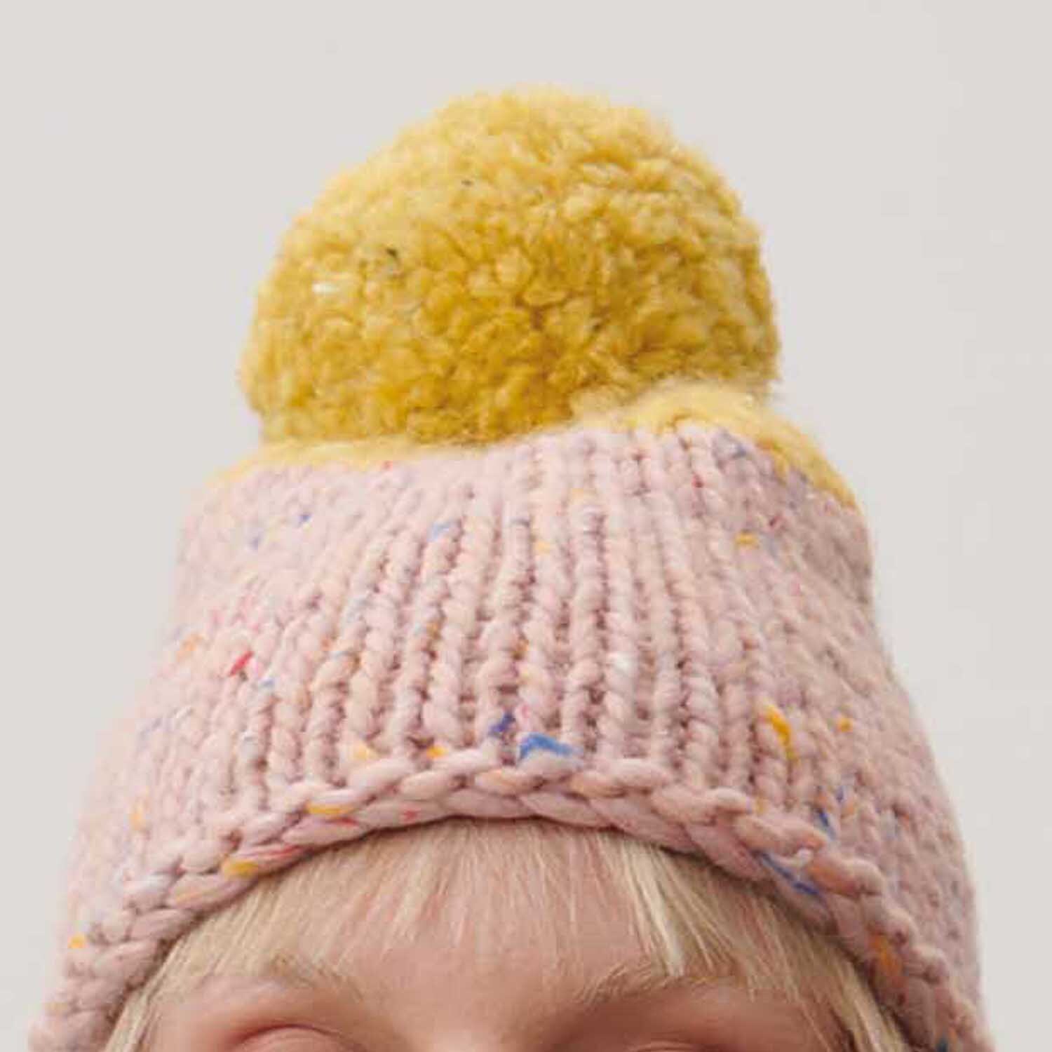 Essentials Super Tweed super chunky Mütze mit gelbem Bommel, gestrickt aus Rico Design Garn.
