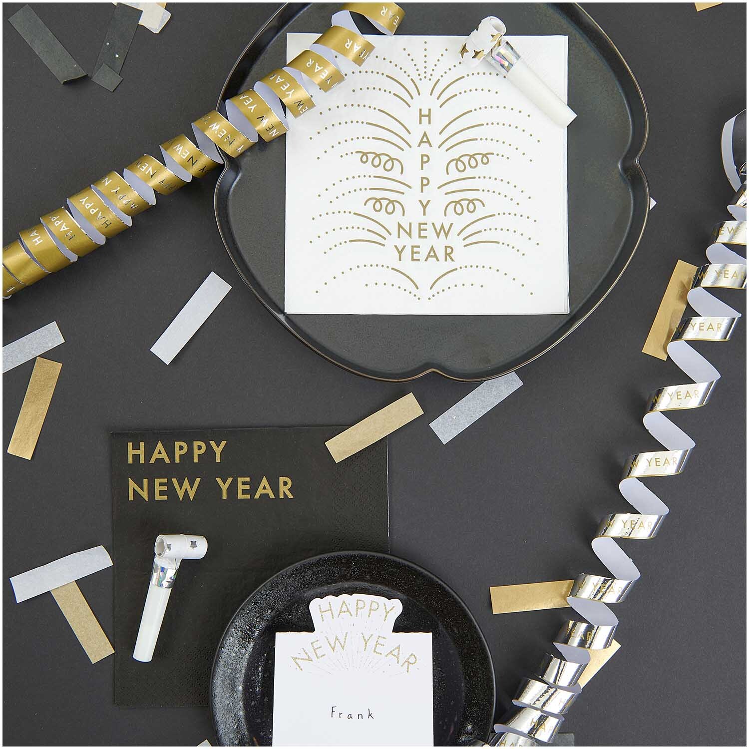 Servietten Happy New Year weiß 33x33cm 20 Stück von Rico Design auf einem Tisch mit Partydekorationen und Konfetti.