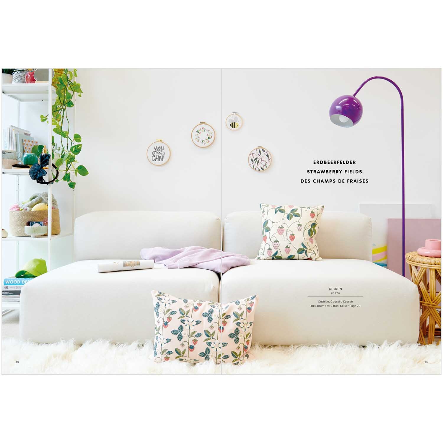 Stickbuch Just Bees + Fruits + Flowers Nr. 181: Helles Wohnzimmer mit weißem Sofa, dekoriert mit floralen Kissen und lila Stehlampe.