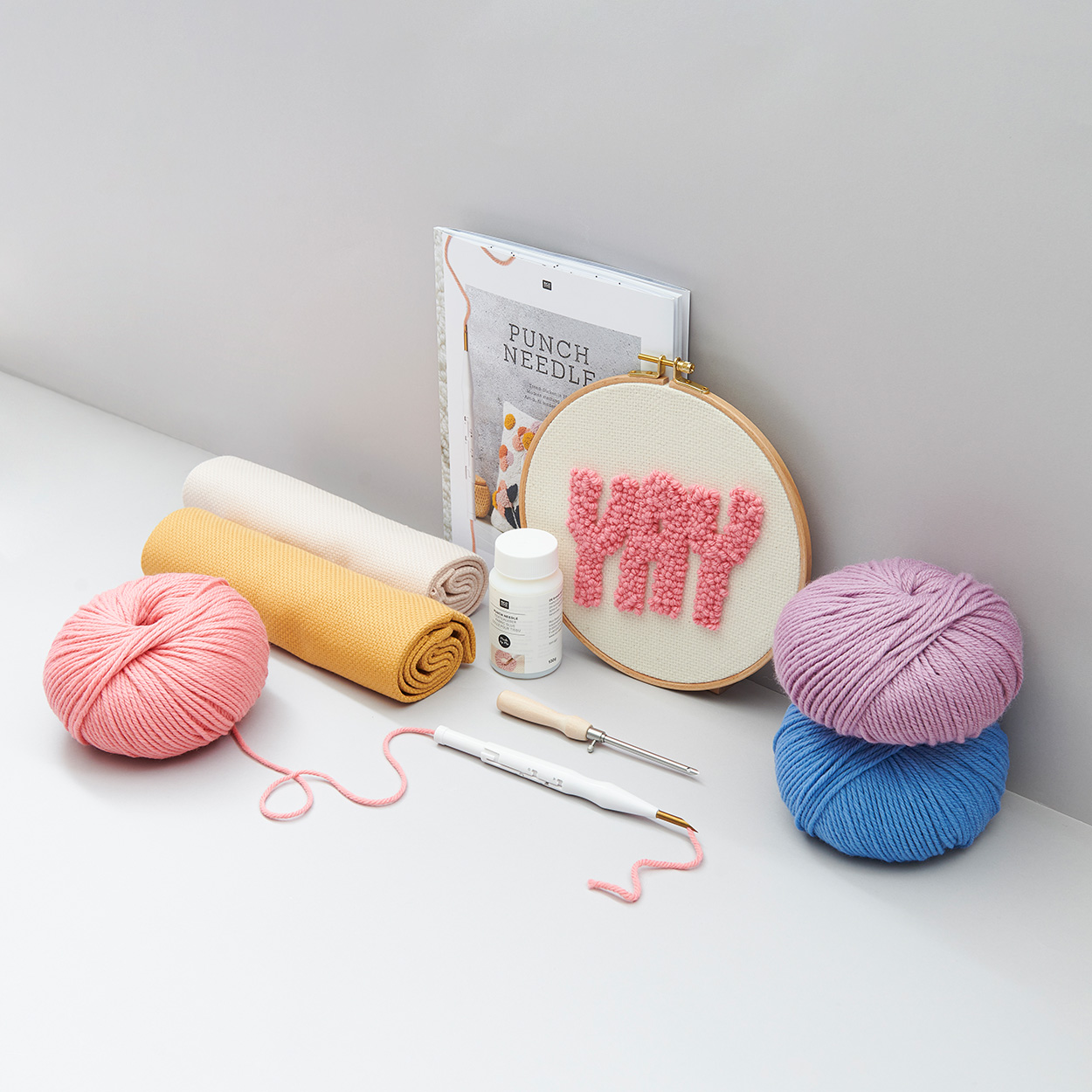 Stickring mit Punch Needle, sowie Garne, Stoffe und Nadeln für Punch Needle. Fotosetting graue Ecke.