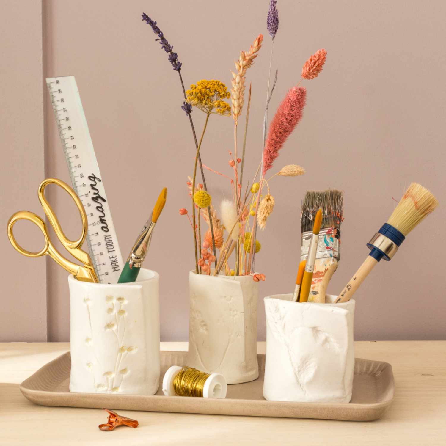 Bastelanleitung florale Gefäße aus Modelliermasse: Drei weiße Gefäße mit Pinseln und Trockenblumen.