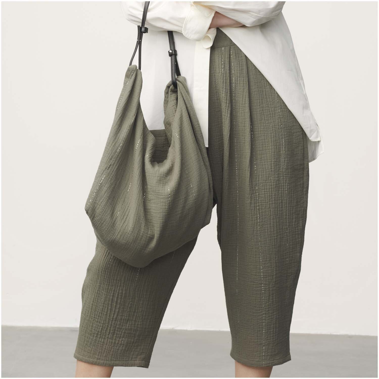 Meterware Krinkelmusselin oliv Hot Foil: Frau trägt olivfarbene Hose und Tasche aus Krinkelmusselin von Rico Design.
