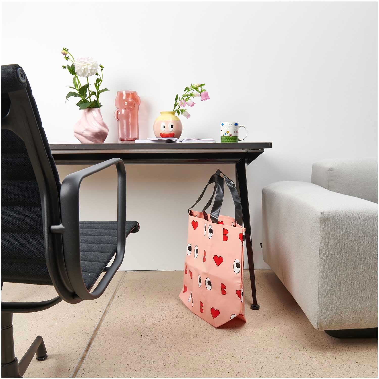 Rico Design x Redfries Shopper Liebe in Rosa neben einem modernen Schreibtisch mit Blumenvasen.
