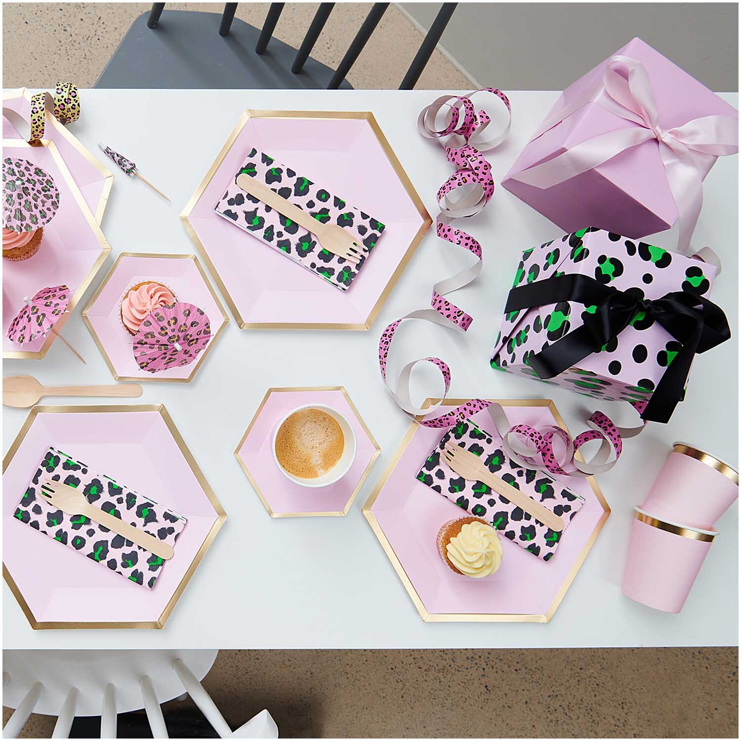 Paper Poetry Geschenkpapier auf einem Tisch mit Geschenken, Tassen und Dekoration in Rosa und Gold.