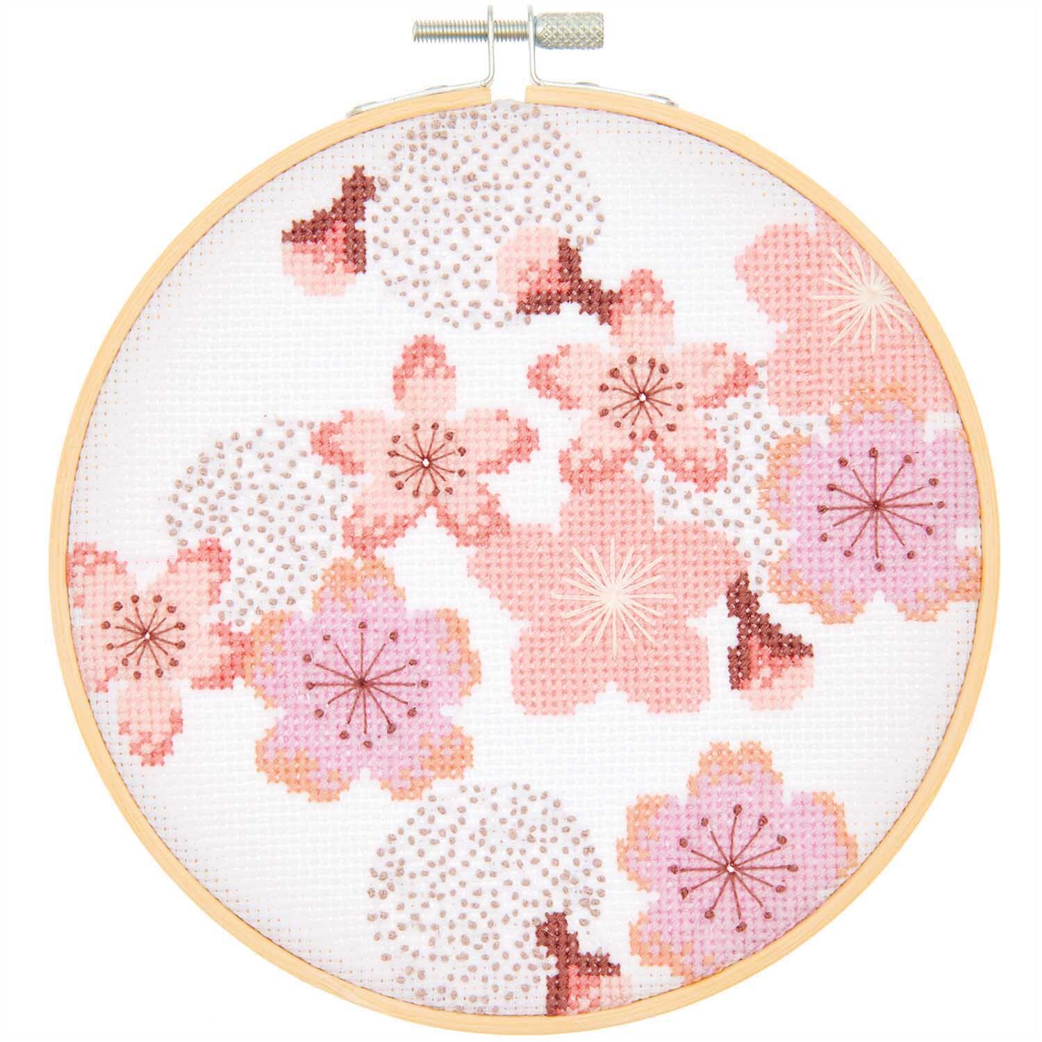 Stickpackung Kirschblüten Bild Ø 15cm zeigt zarte rosa Kirschblüten in einem runden Stickrahmen.