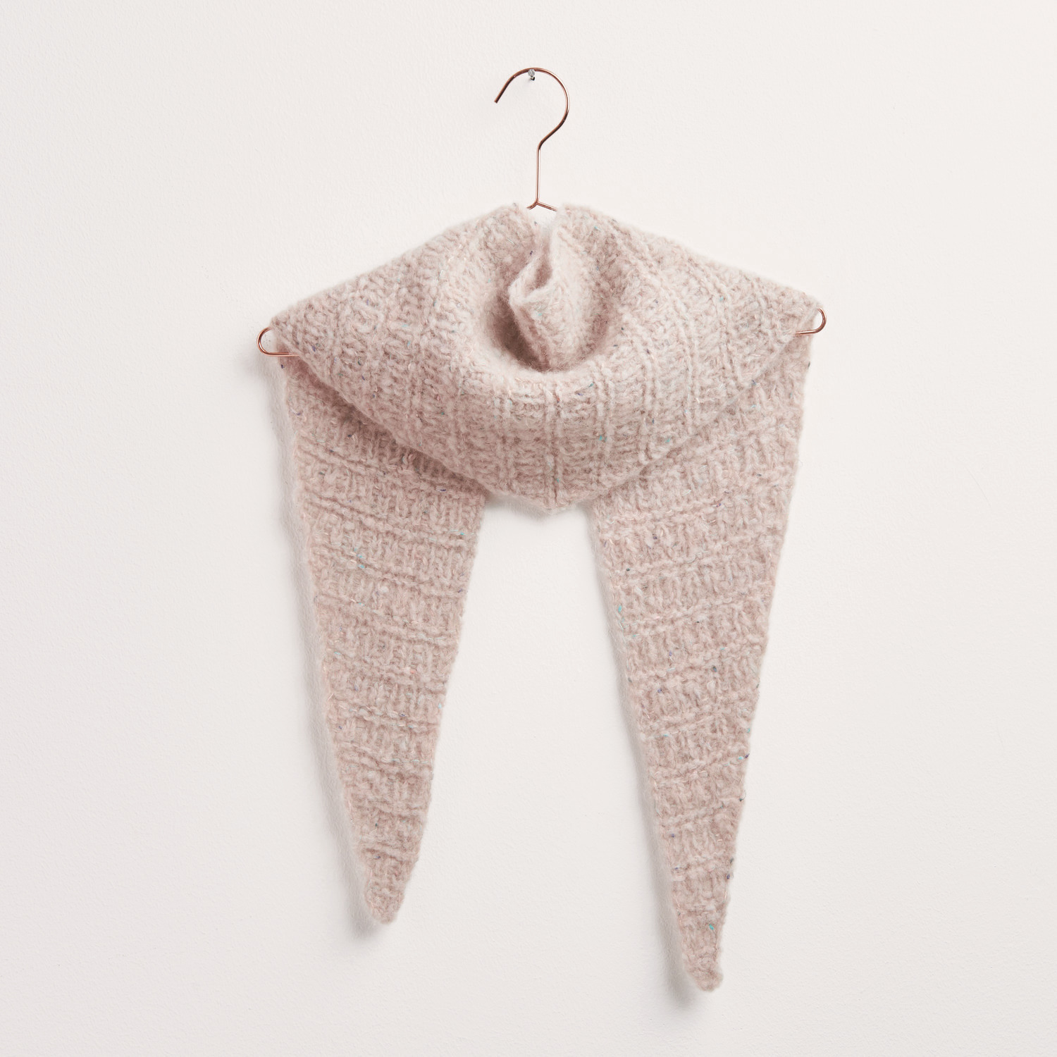 Strickset Dreieckstuch Modell 04a in Puder auf einem Kleiderbügel, aus weichem Alpaka-Garn.