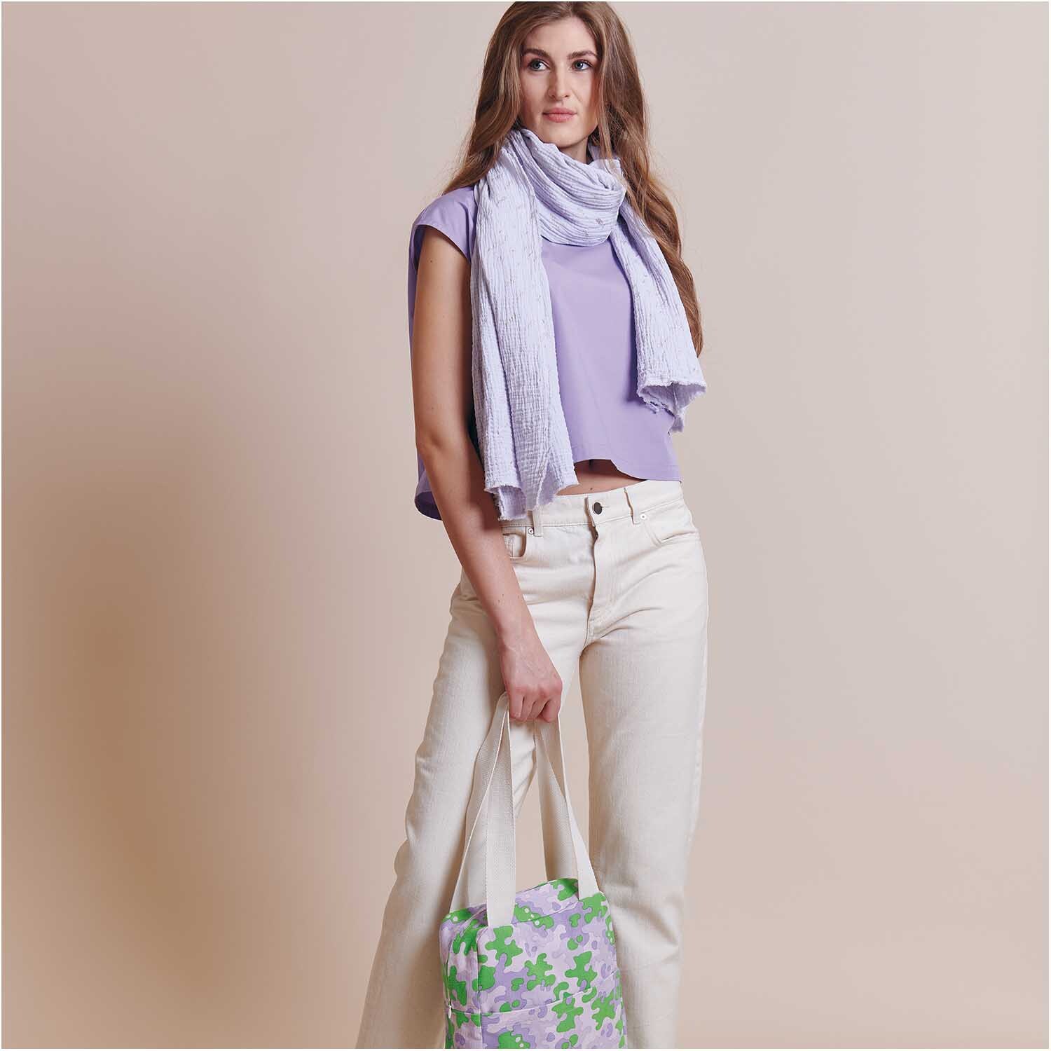 Meterware Krinkelmusselin hellgrau Hot Foil: Frau in lila Oberteil mit hellgrauem Schal und Tasche mit Blumenmuster.