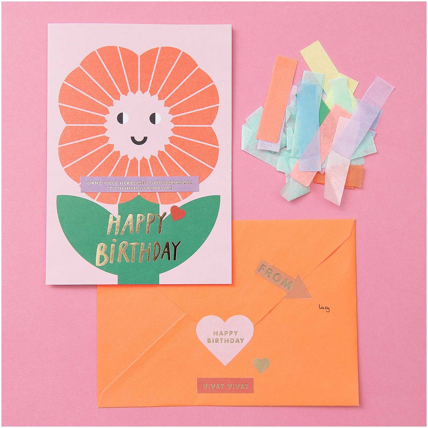 Paper Poetry Grußkartenset Happy Birthday mit bunter Blume, Umschlag und Konfetti auf rosa Hintergrund.