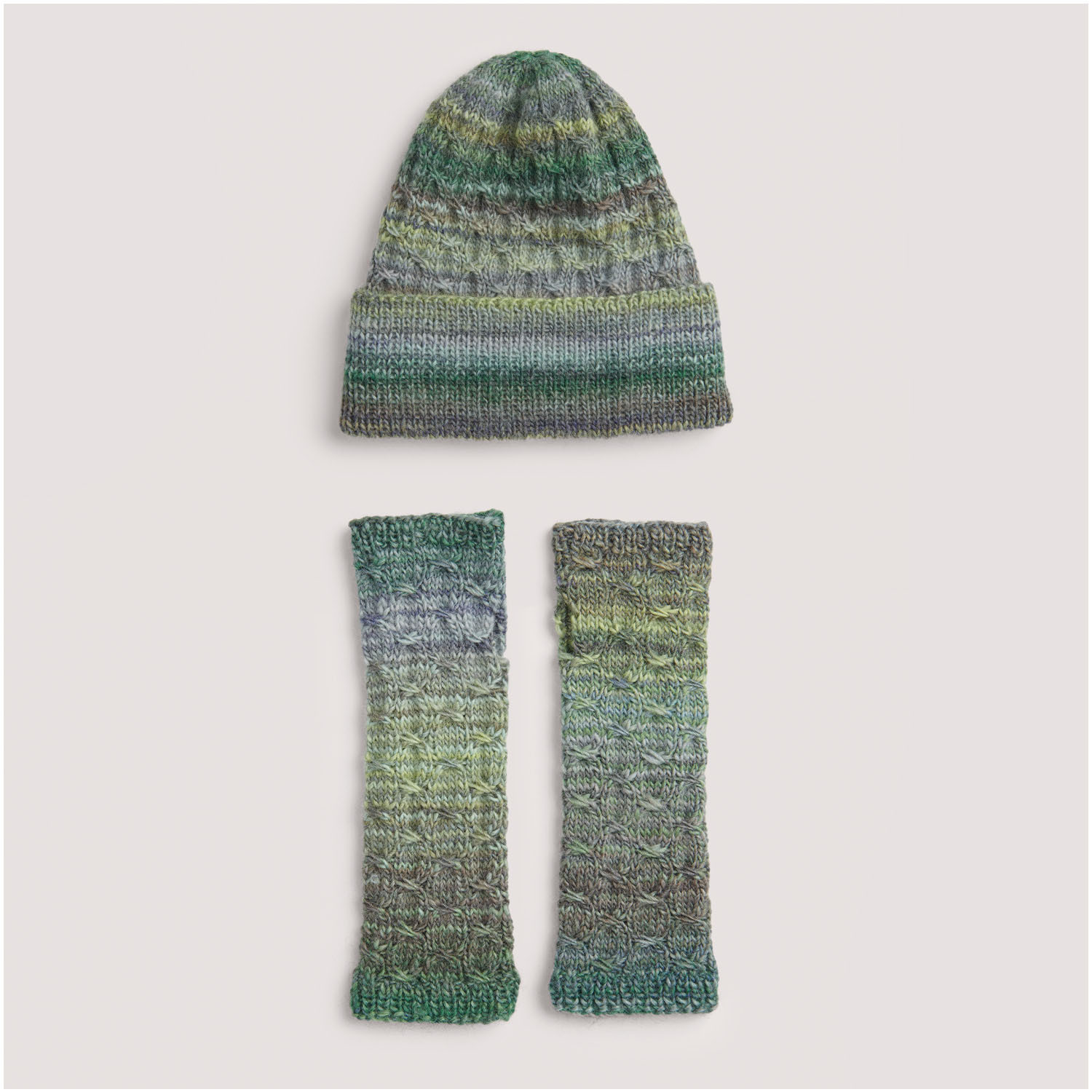 Strickset bestehend aus einer Mütze und Armstulpen in grünen und grauen Tönen. Marke: Die Neue Masche Nr. 8. Titel: Modell 12 und 13. Perfekt für kühle Tage.