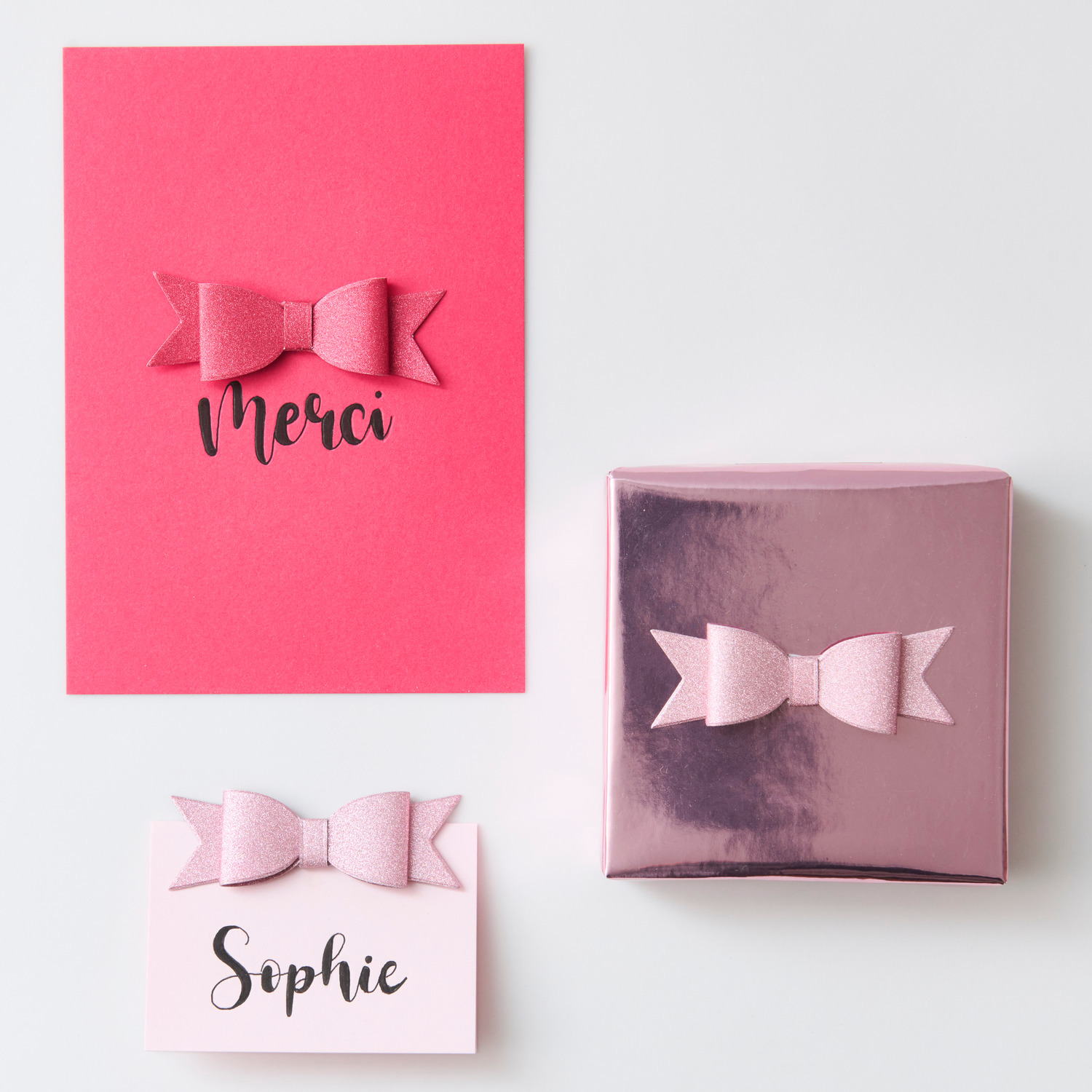 Paper Poetry 3D Sticker Schleifen Glitter: Rosa Schleifen auf Karten und Geschenkbox, ideal für kreative Dekorationen.