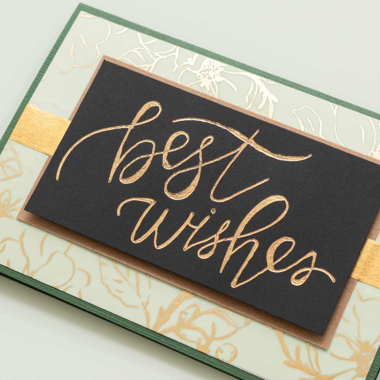 Foil Quill Freestyle Pen Kit: Handgeschriebene Karte mit goldener Schrift auf schwarzem Hintergrund, umgeben von floralen Mustern.