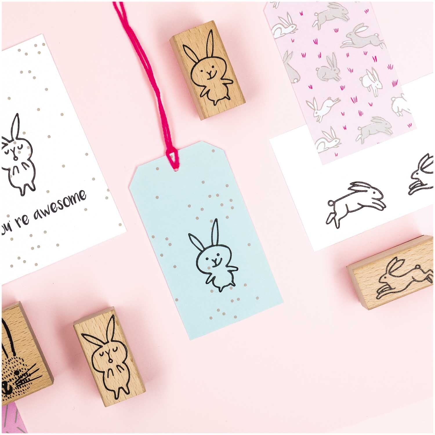Paper Poetry Stempelset Hasen: Sechs Stempel mit Hasenmotiven auf rosa Hintergrund, ideal für kreative Projekte.