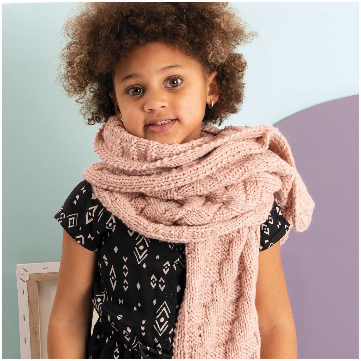 Essentials Alpaca Blend chunky Schal in Puder, getragen von einem Kind, zeigt weiche Stricktextur. Ideal für kalte Tage.
