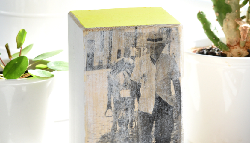 Bastelanleitung Fototransfer auf Holz: Schwarz-weißes Bild auf Holzblock, umgeben von Pflanzen.