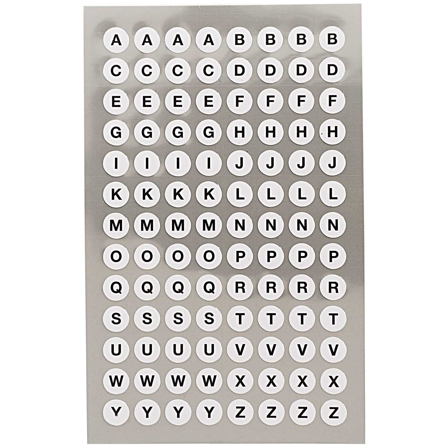 Paper Poetry OfficeSticker zeigt weiße Buchstaben auf runden Aufklebern. Perfekt für kreative Projekte.