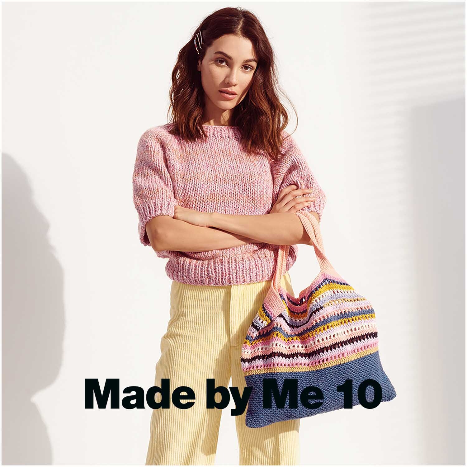 Creative Lazy Hazy Summer Cotton dk: Frau in pastellfarbenem Strickpullover mit gestreifter Tasche.