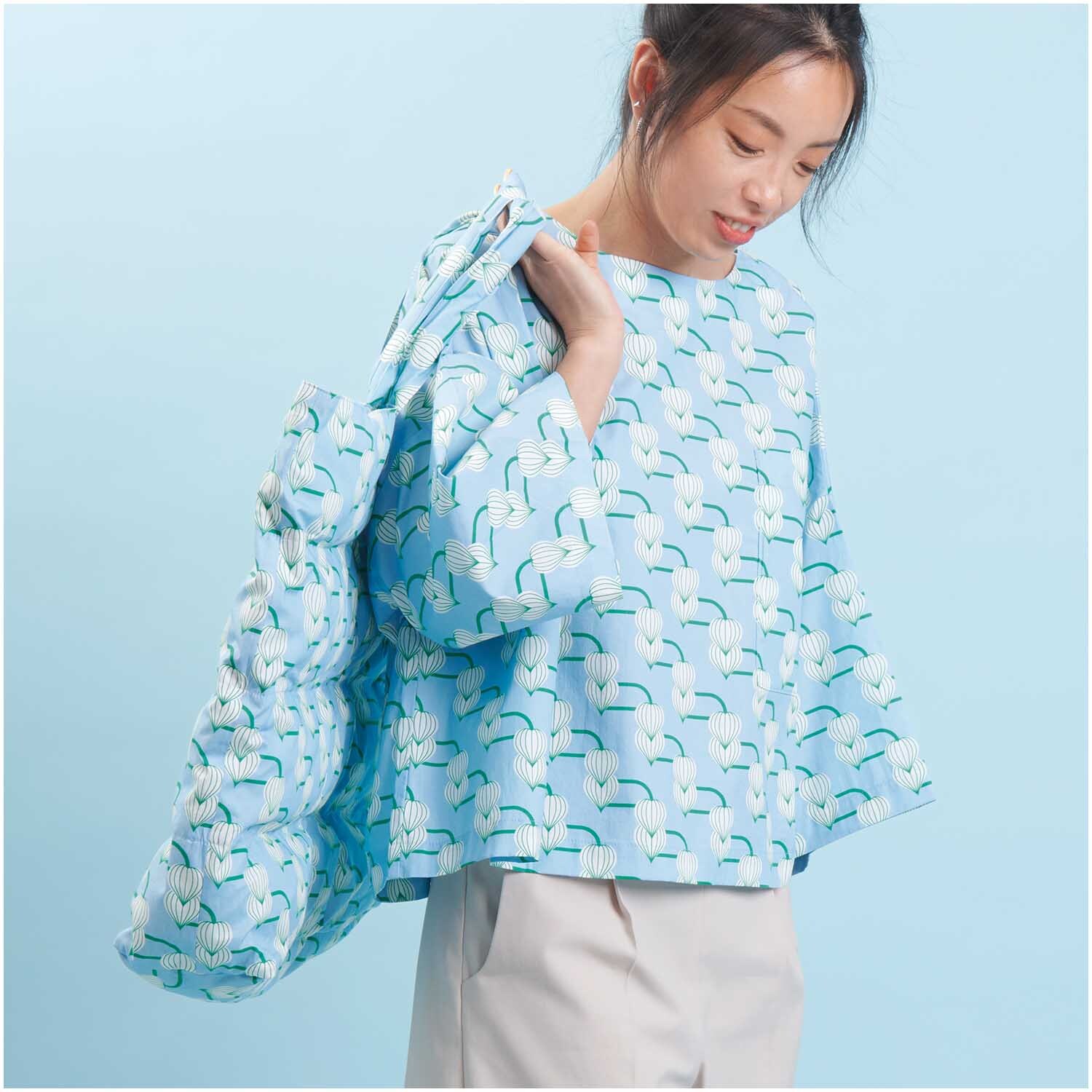 Meterware Baumwoll-Popelin blau Knospen: Frau trägt ein Outfit aus gemustertem Stoff von Rico Design.