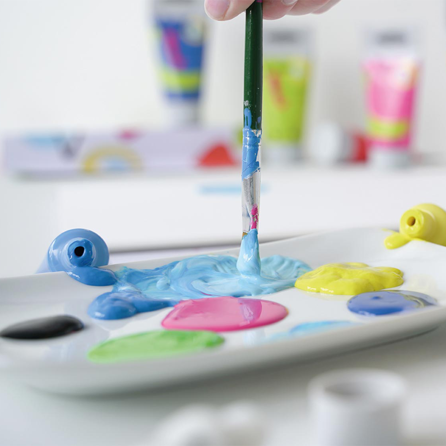 Kids Art Kinder-Künstlerfarbe: Ein Pinsel mischt bunte Farben auf einer Palette, ideal für kreative Projekte.