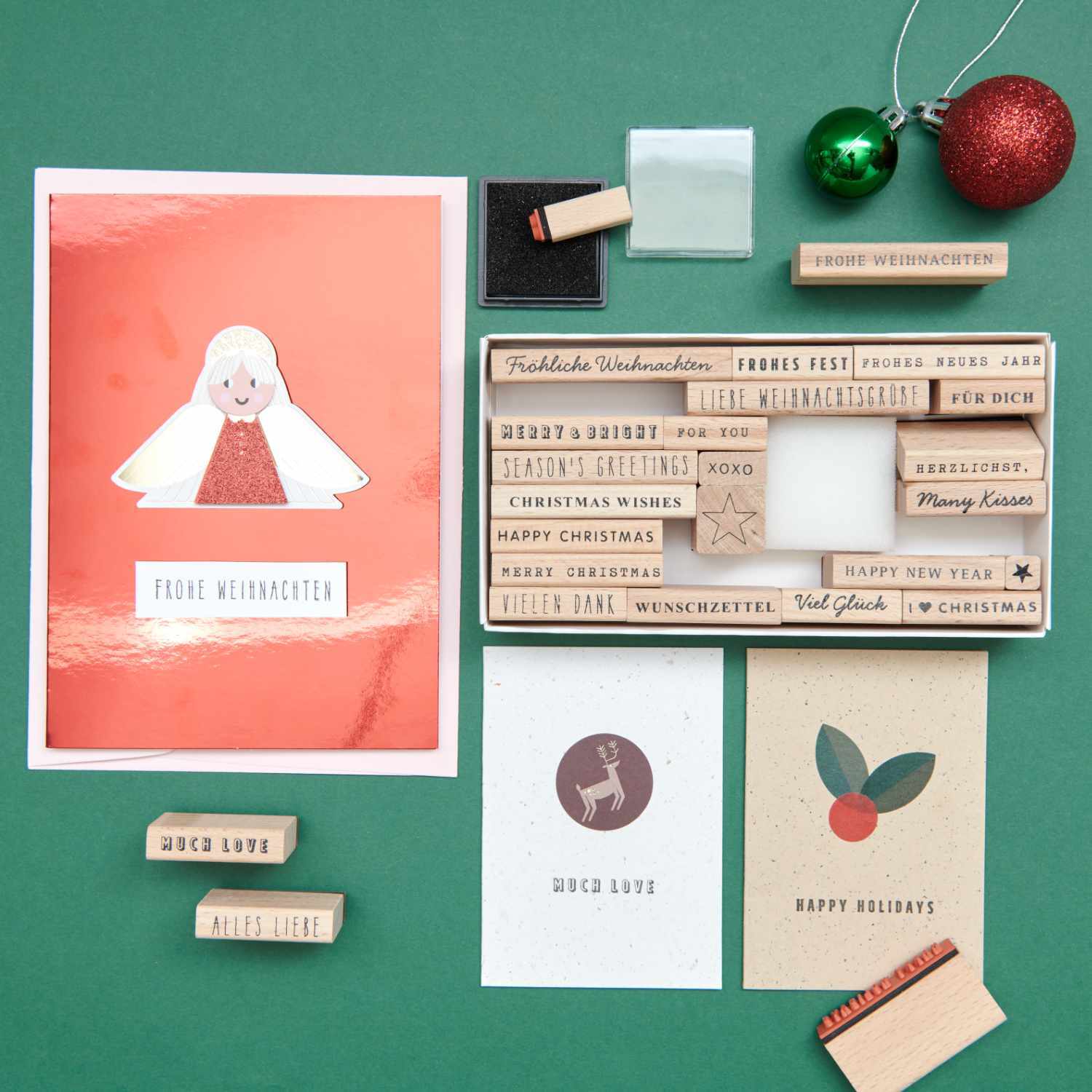 Paper Poetry XL Stempelset Merry Christmas mixed type, 27-teilig, auf grünem Hintergrund mit Weihnachtskarten und Dekoration.