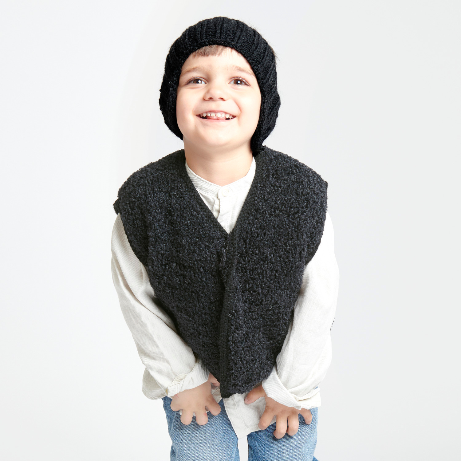 Creative Teddy: Kind trägt schwarze Weste und Mütze von Rico Design, lächelt in die Kamera.