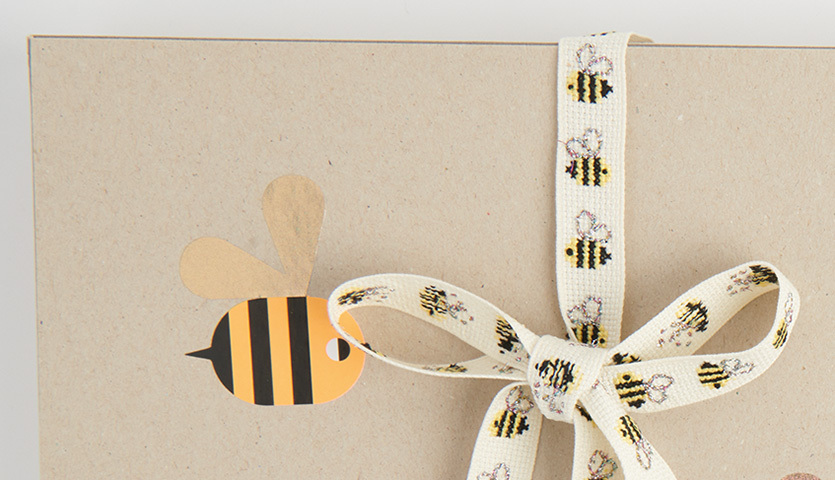 Stickanleitung für ein Geschenkband mit Bienenmotiv, ideal für kreative Bastelprojekte.