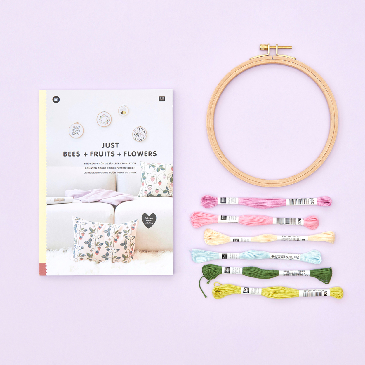 Stickbuch daneben ein leerer Stickring und verschiedene Garne zum Sticken. Flatlay von Produkten.