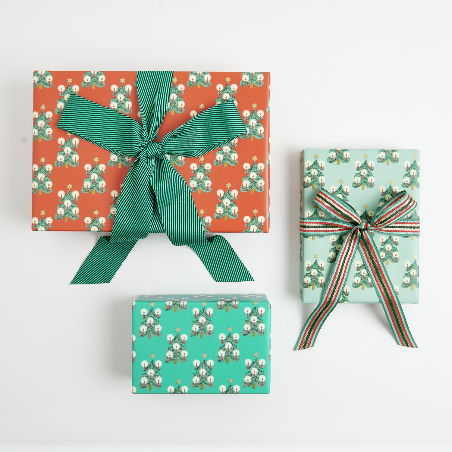 Paper Poetry Geschenkpapier Tannenbäume Mix, drei Geschenke mit Tannenbaum-Muster und Bändern.