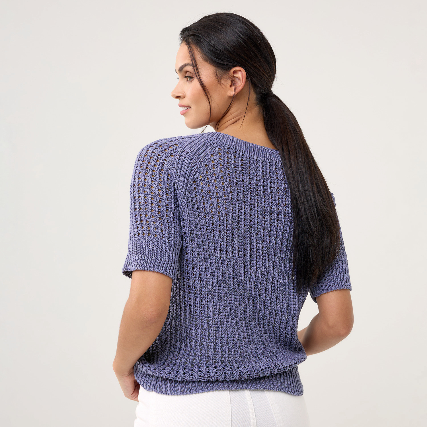 Die Neue Masche Nr. 09 Frühjahr-Sommer: Frau trägt lila Strickpullover von Wolle Rödel, Rückansicht.