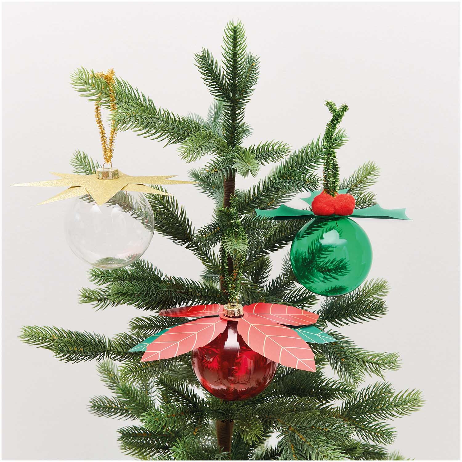 Paper Poetry Christbaumkugel-Topper Ilex in Gold, Rot und Grün schmücken einen Tannenbaum. Ideal für festliche Dekoration.