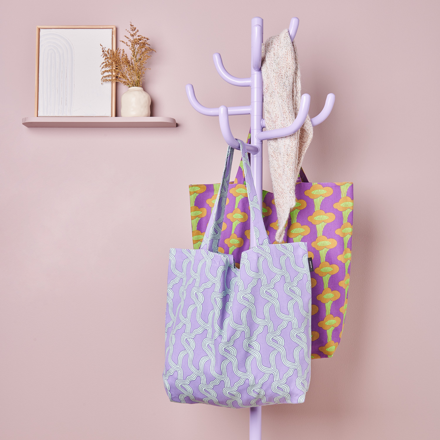 Canvas-Shopper Pfifferlinge Neon Violett und Myzel Flieder hängen an einem pastellfarbenen Kleiderständer.