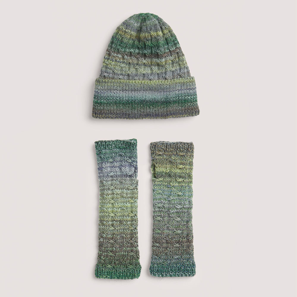 Mütze+Armstulpen auf grauem Hintergrund – zum Strickset