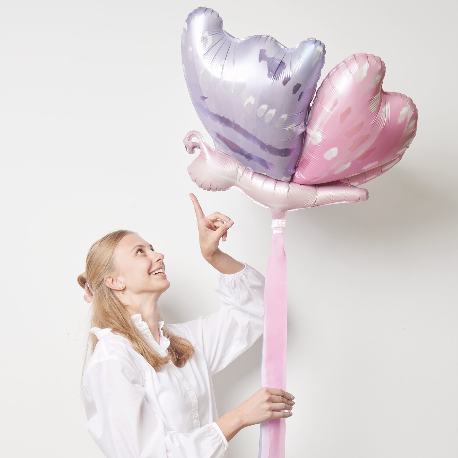 Folienballon 3D-Schmetterling Blau/Rosa, 58x54cm, von Rico Design. Frau hält den bunten Ballon.