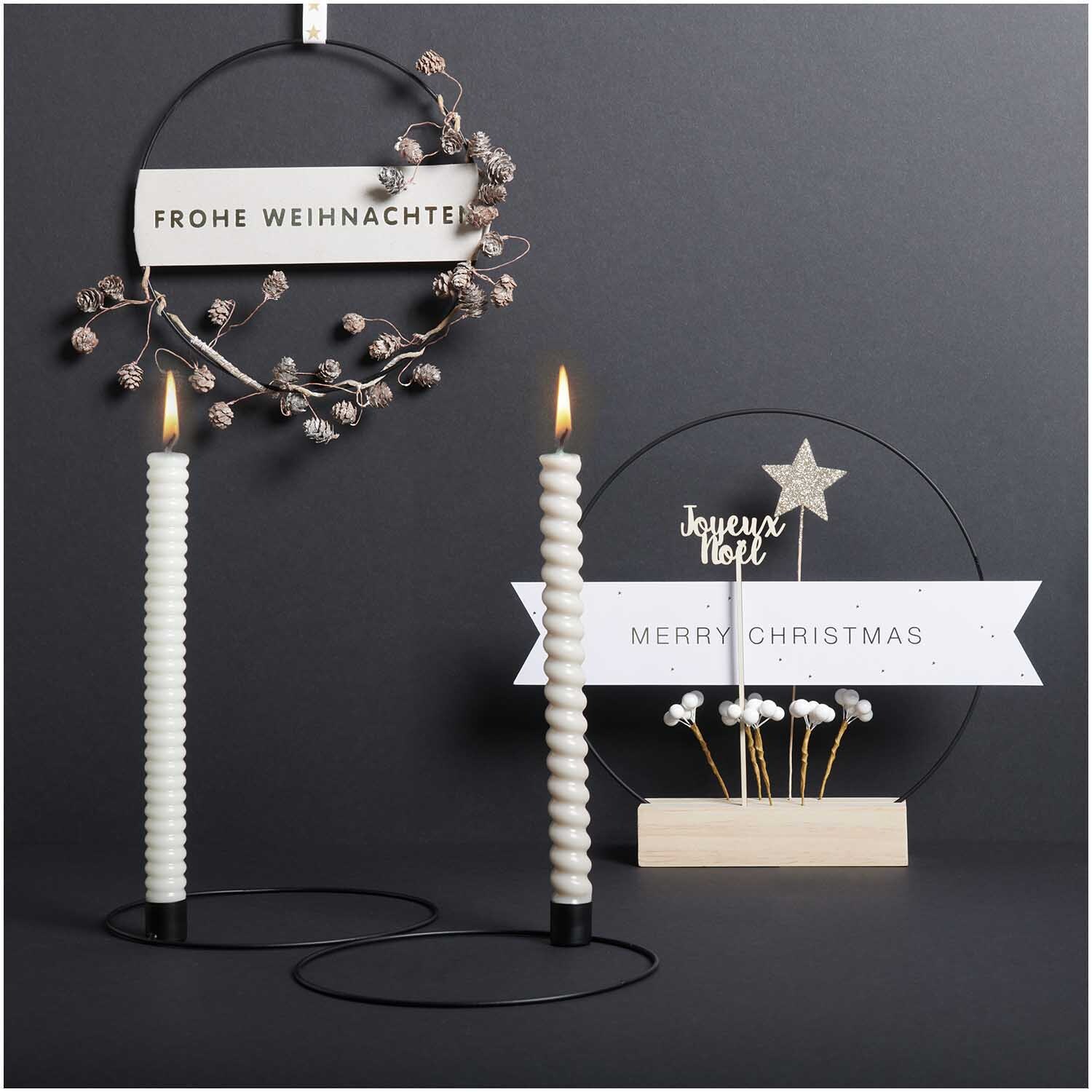 Metallring mit Kerzenhalter Ø 20cm, dekoriert mit weißen Kerzen und weihnachtlichen Elementen auf schwarzem Hintergrund.