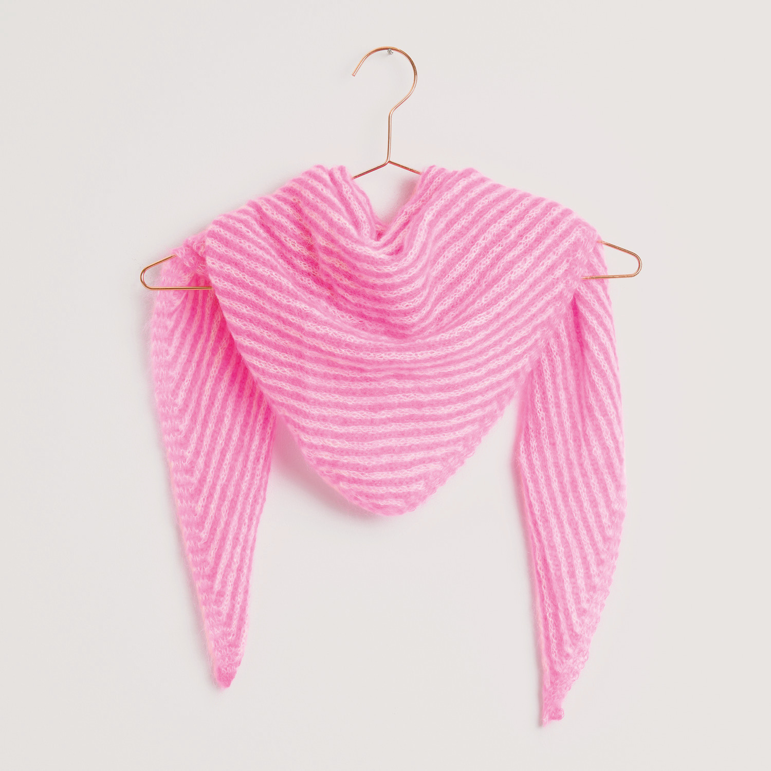 Essentials Super Kid Mohair Loves Silk: Dreieckstuch in Weiß und Neon-Pink von Rico Design, elegant drapiert auf einem Kleiderbügel.
